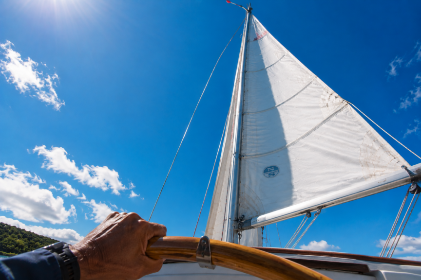 Skipper looking up the mast at a Windex while sailing on a port tack.